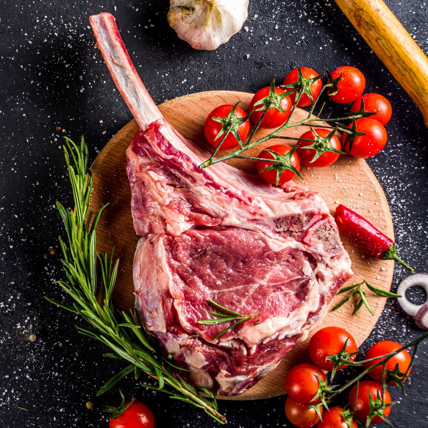 Tomahawk Steak crudo con romero y tomates cherry, corte gourmet de res mexicana ideal para parrilla.
