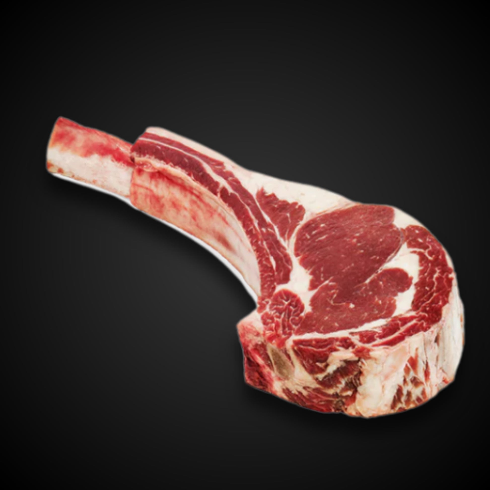 Tomahawk Steak de Cortes Celorio sobre fondo negro, corte grueso con hueso largo y marmoleo perfecto.